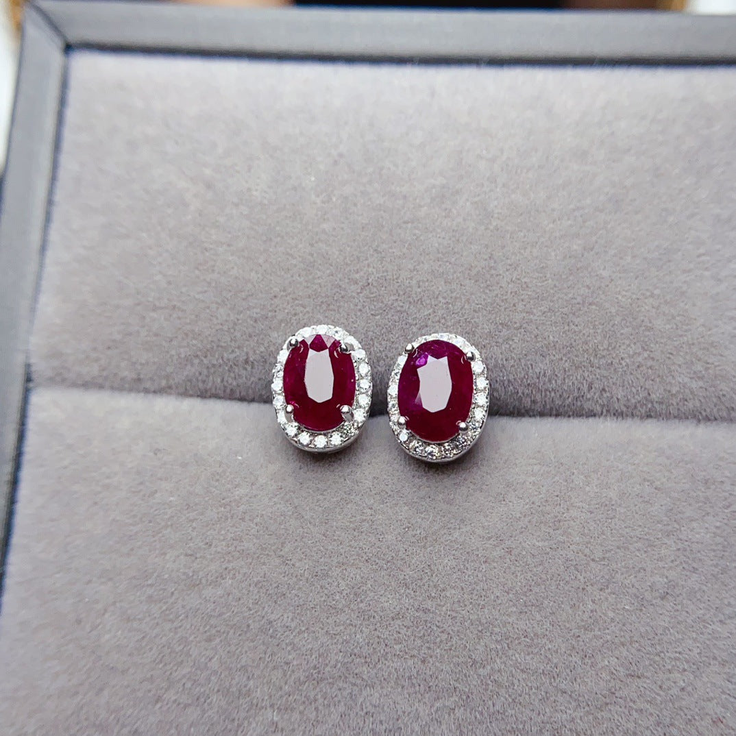 Ruby Oval Cut Stud Earrings in Sterling Silver with Halo Design