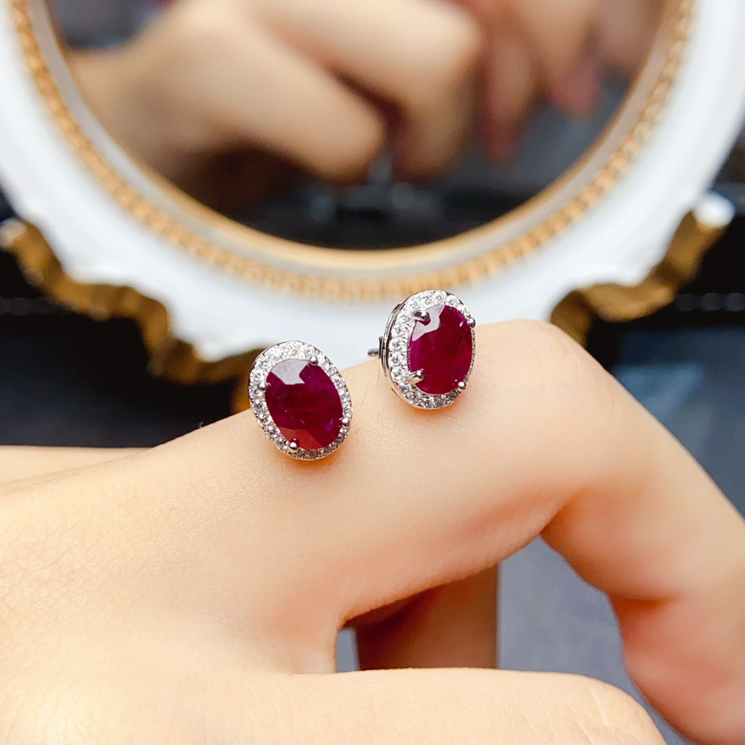 Ruby Oval Cut Stud Earrings in Sterling Silver with Halo Design