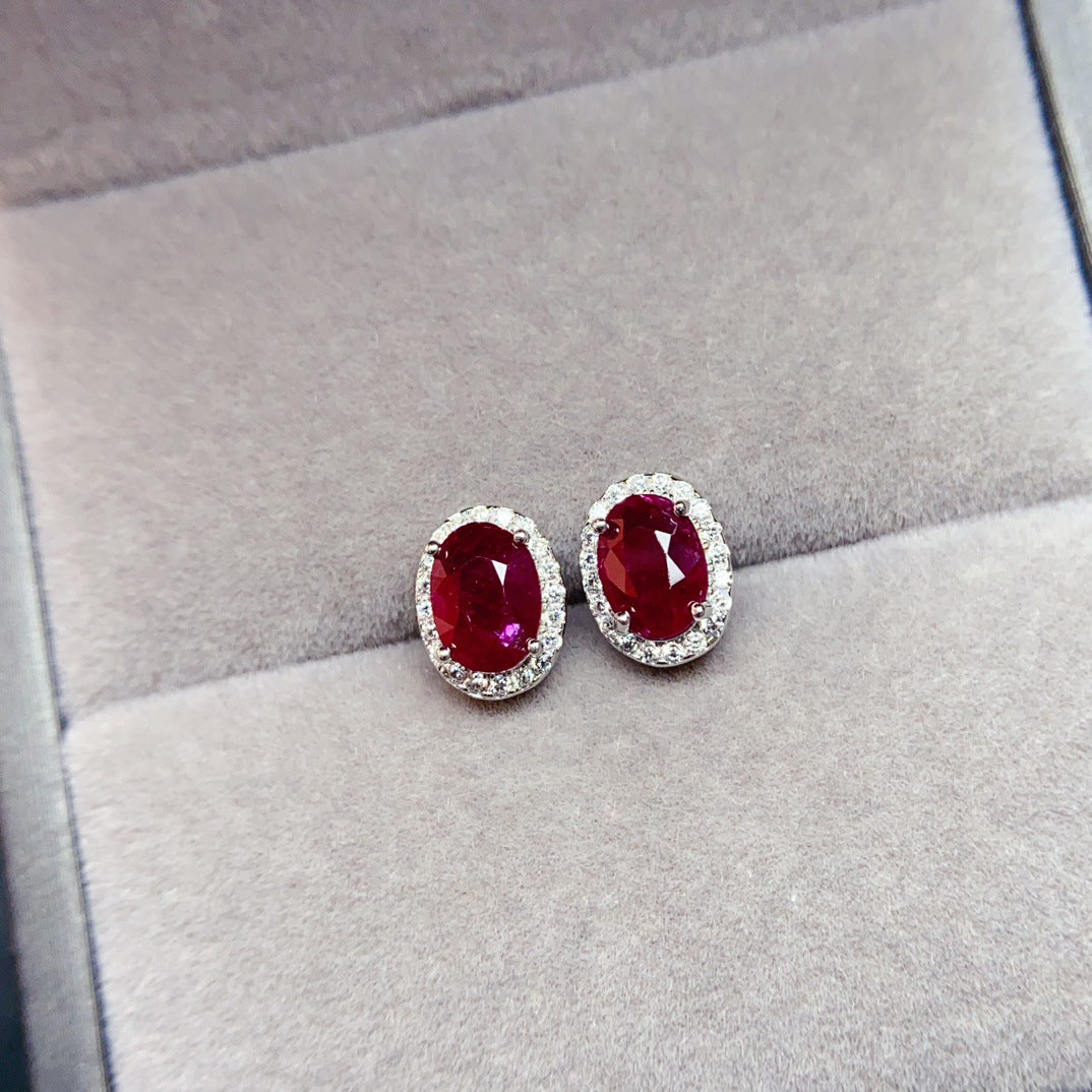 Ruby Oval Cut Stud Earrings in Sterling Silver with Halo Design